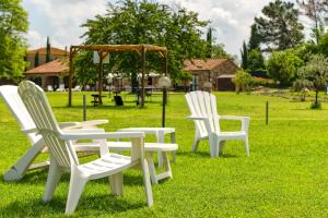 drie witte stoelen in het gras in een park bij Hotiday Massa Marittima in Massa Marittima +34 foto's
