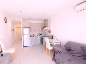una cucina bianca con tavolo e frigorifero di 2 Bed Apartment close to the beach and Siam park ad Adeje