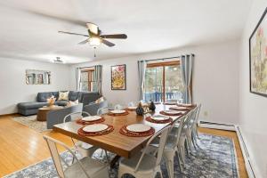 a dining room with a long table and chairs at Dual Home Retreat! Walk Between Both! Sleeps 28 in Newfield