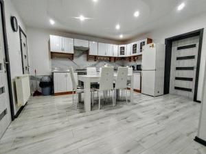 a kitchen with a table and white chairs in it at Apartmán Sofia Centrum in Michalovce