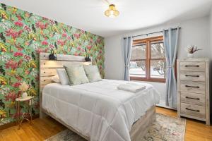 a bedroom with a bed with a floral wallpaper at Dual Home Retreat! Walk Between Both! Sleeps 28 in Newfield
