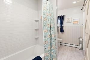 a bathroom with a shower with a shower curtain at Dual Home Retreat! Walk Between Both! Sleeps 28 in Newfield +82 photos