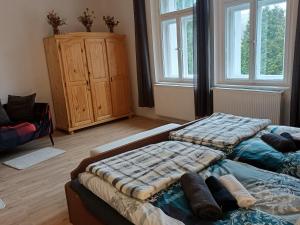 a bedroom with two beds and a cabinet and windows at Podhradí 24 in Jáchymov