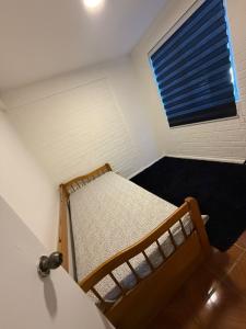 a small bedroom with a bed and a window at Departamento cerca de la playa in La Serena