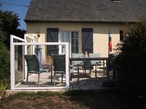 un patio con tavolo e sedie davanti a una casa di Le Logis Des Grenouilles B&B a Morieux