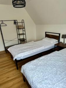 2 aparte bedden in een kamer met een ladder bij Ferienwohnung am Bürgerpark in Verden