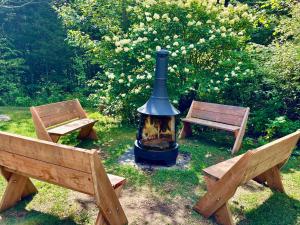 a fire pit with two benches in a park at Merle Bleu in Wentworth