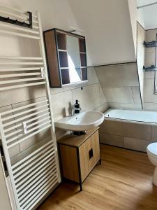 a bathroom with a sink and a toilet and a tub at Ferienwohnung am Bürgerpark in Verden +8 photos