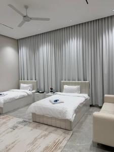 ein Schlafzimmer mit zwei Betten und einem Deckenventilator in der Unterkunft فلة الشروق - Sunrise Villa in Sur