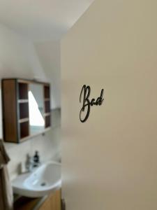 a bathroom with a sink and a sign that says bed at Ferienwohnung am Bürgerpark in Verden