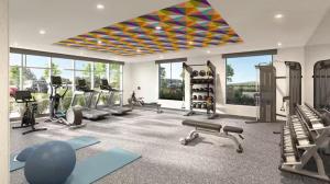 Un gimnasio con varios equipos de ejercicio en una habitación con ventanas. en Home 2 Suites, en Hernando