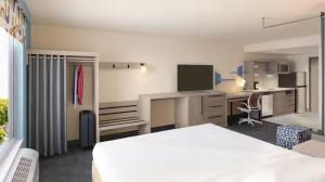 Un dormitorio con una cama y un escritorio con una computadora. en Home 2 Suites, en Hernando