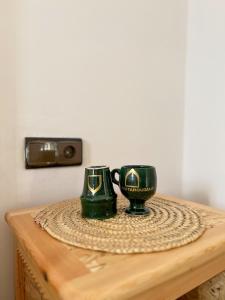 zwei grüne Tassen auf einem Holztisch in der Unterkunft Palais Taroudant in Taroudant