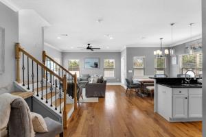 a kitchen and living room with a staircase and a dining room at Sunlit Sands in Inlet Beach