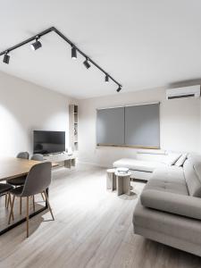 ティラナにある2BR at Artist's Palace - Skanderbeg Square Viewsのソファとテーブルのある白いリビングルーム