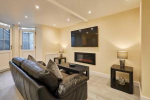 a living room with a leather couch and a fireplace at Host & Stay - Ross's View in Whitby