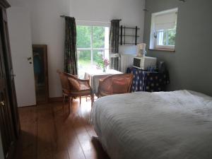 a bedroom with a bed and a table and a window at Maison De Blanche Neige in Court-Saint-Étienne