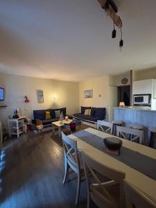 a living room with a couch and tables and chairs at Les Terrasses des Sables Blancs in Douarnenez