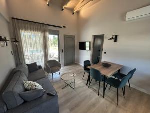 Olive Grove Villas Galaxidi في غالاكسيدي: غرفة معيشة مع أريكة وطاولة