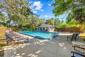 una piscina con sedie e una casa di Beach Front Escape with Private Deck & Beach Access, Pet Friendly a Manasota Beach