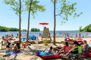 a group of people sitting on a beach at Comfy 2BR Pierrefonds Apt with included parking in Montréal