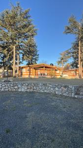 ein großes Holzhaus mit einer Steinmauer in der Unterkunft Cabañas Alvear in Huerta Grande