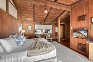 una camera con un grande letto e pareti in legno di Beach Front Escape with Private Deck & Beach Access, Pet Friendly a Manasota Beach