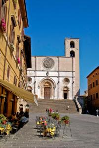uma igreja com mesas e cadeiras em frente a um edifício em Grazioso Appartamento in Centro con Vista em Todi