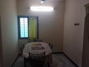 een kamer met een tafel met stoelen en een raam bij ss Lodge & cottage in Allinagaram