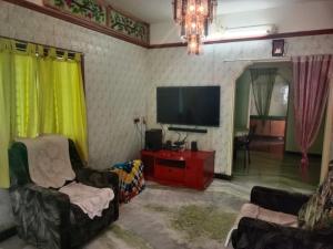 een woonkamer met 2 stoelen en een flatscreen-tv bij ss Lodge & cottage in Allinagaram