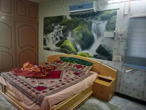 een slaapkamer met een bed met een schilderij aan de muur bij ss Lodge & cottage in Allinagaram