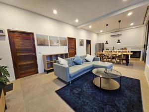 a living room with a couch and a table at v15 Ocean Serenity Residence in Ko Phangan