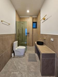 une salle de bains avec toilettes et douche en verre dans l'établissement v15 Ocean Serenity Residence, à Ko Pha Ngan
