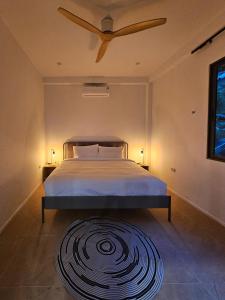 - une chambre avec un lit, un ventilateur de plafond et un tapis dans l'établissement v15 Ocean Serenity Residence, à Ko Pha Ngan