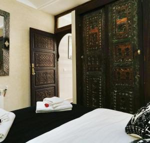 a bedroom with an open door with towels on a bed at Riad Beata - Private use option - in Marrakech