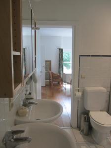 a bathroom with two sinks and a toilet at Maison De Blanche Neige in Court-Saint-Étienne