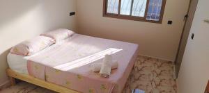 ein kleines Schlafzimmer mit einem rosa Bett mit Schuhen drauf in der Unterkunft Dar Fatima in Aït Ali + 6 Fotos