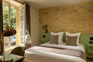 尼姆普利伽罗弗里酒店的一间带床和石墙的卧室