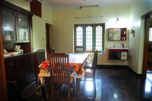 une salle à manger avec une table et des chaises et une cuisine dans l'établissement Home Near Sabarimala, à Rānī 5 autres photos