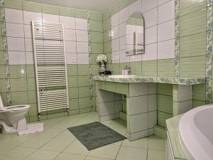 baño verde y blanco con lavabo y aseo en Apartmán Sofia Centrum, en Michalovce 29 fotos más