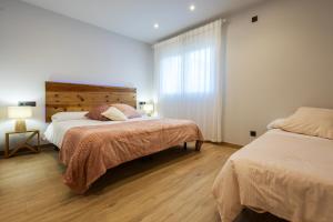 a bedroom with two beds and a window at Bizi Baztan Goienetxea in Elizondo