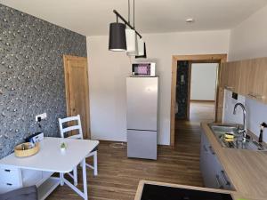 a kitchen with a white table and a refrigerator at NEU! Ferienwohnung HappyNest in Sondershausen