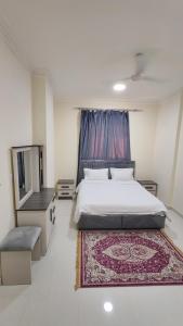 a bedroom with a bed and a rug on the floor at صلالة الوسطى - نسائم صلاله للأجنحة والشقق الفاخرة Nassayem Salalah Hotel Apartments & Suites Salalah Center in Salalah
