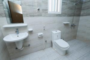 a bathroom with a toilet and a sink and a mirror at صلالة الوسطى - نسائم صلاله للأجنحة والشقق الفاخرة Nassayem Salalah Hotel Apartments & Suites Salalah Center in Salalah