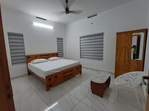 a bedroom with a bed and a chair in it at The white luxury Homestay in Thekkady
