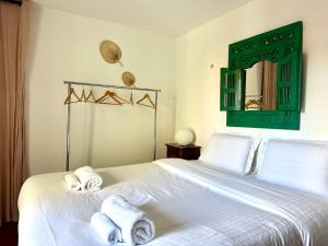 a bedroom with a white bed with towels on it at L'âme de Nice - Terrasse dorée sur Place Masséna in Nice