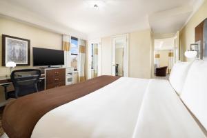 a hotel room with a large bed and a desk at New Yorker by Lotte Hotels in New York