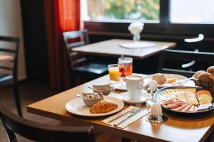 a table with breakfast foods and drinks on it at Boutique Hotel Waldegg - Self-Check-in in Luzern