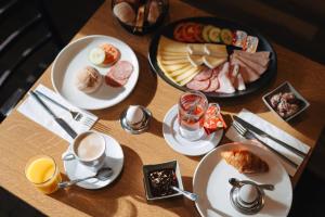 a wooden table with plates of breakfast foods and drinks at Boutique Hotel Waldegg - Self-Check-in in Luzern +39 photos