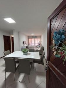 Apto 101 Edifício Manoel Teixeira في أرويو دو سيلفا: غرفة طعام مع طاولة بيضاء وكراسي +6 صور